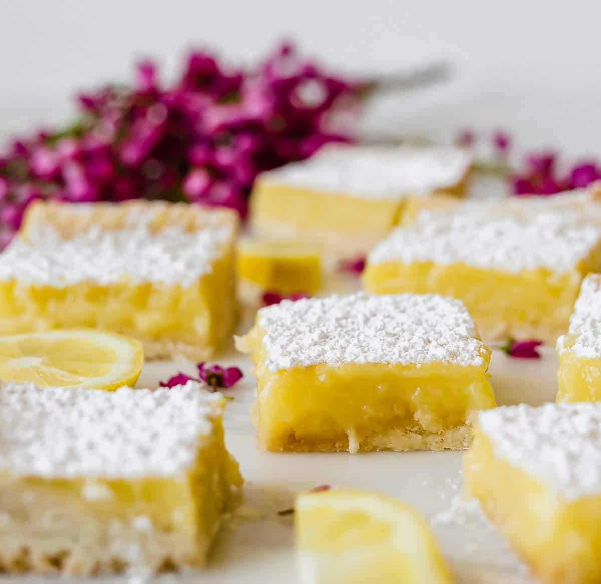 Lemon bars sitting on a piece of marble.