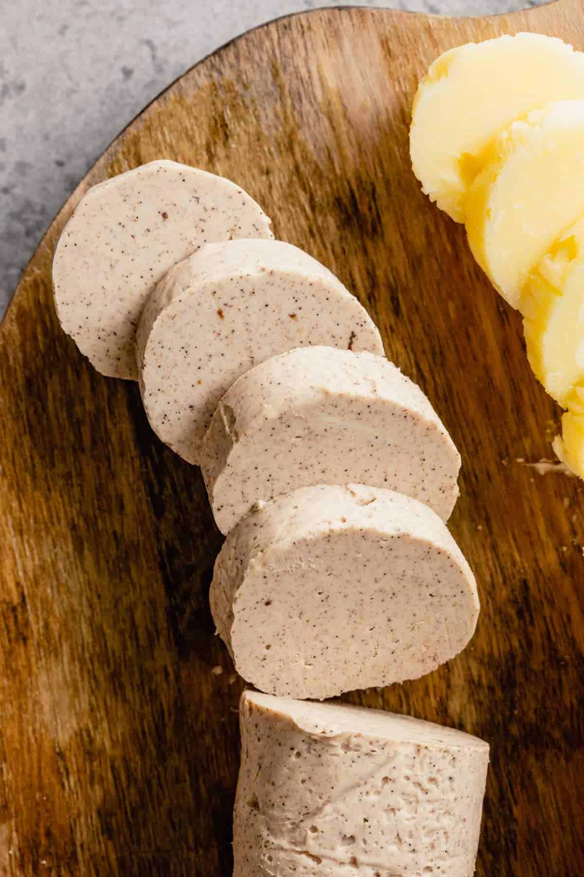 A top down photo or cinnamon compound butter on a wooden cutting board with honey butter to the right.