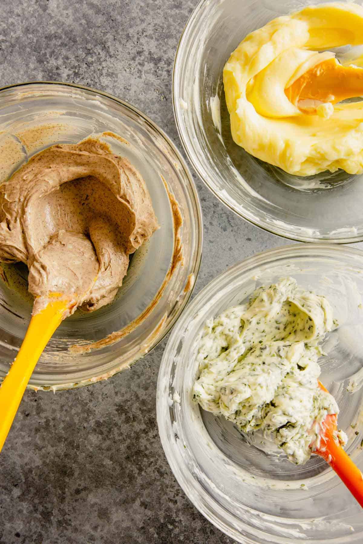 Three bowls with compound butter mixed until smooth.