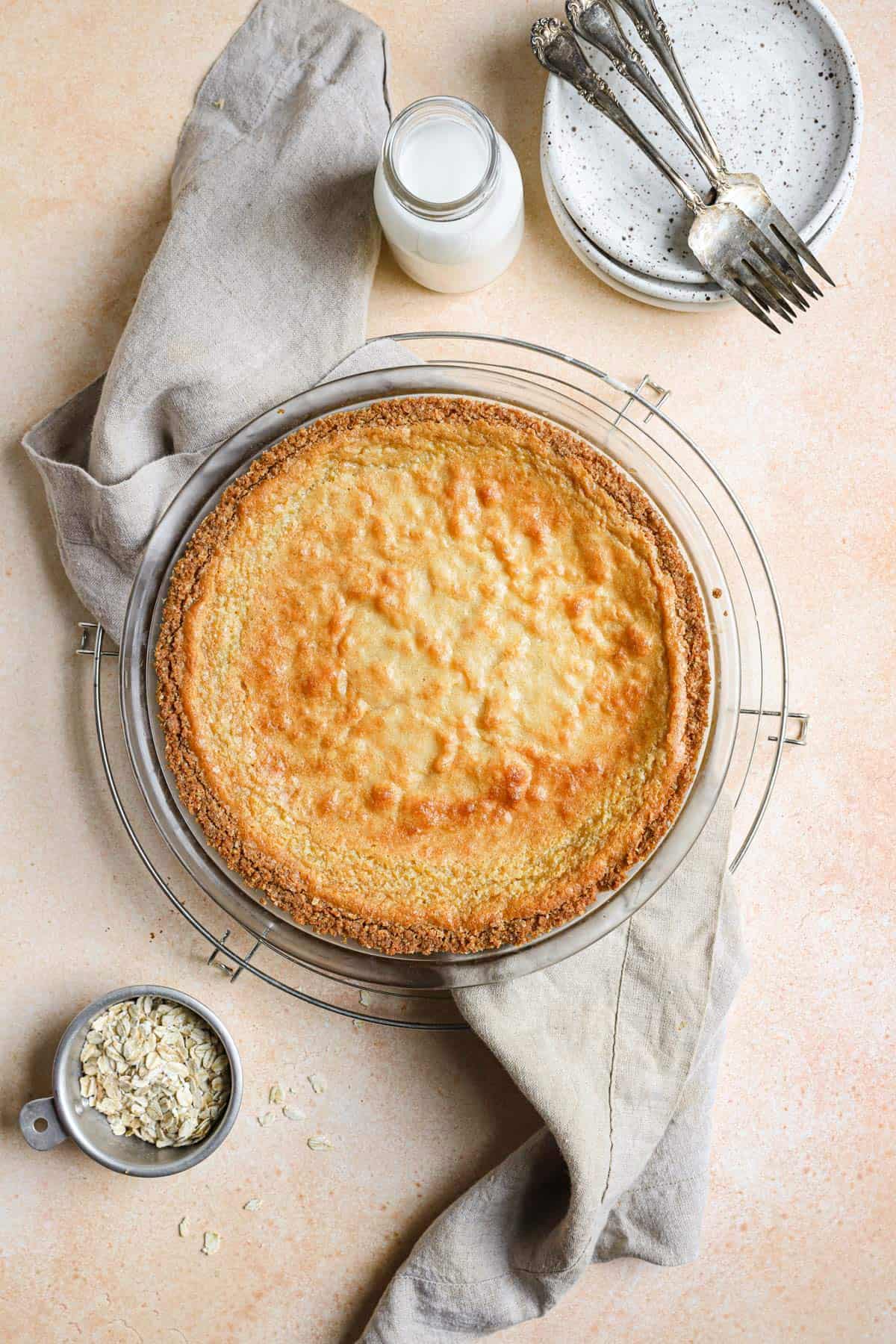 A milk bar crack pie on a cooling rack with a dish towel under it.