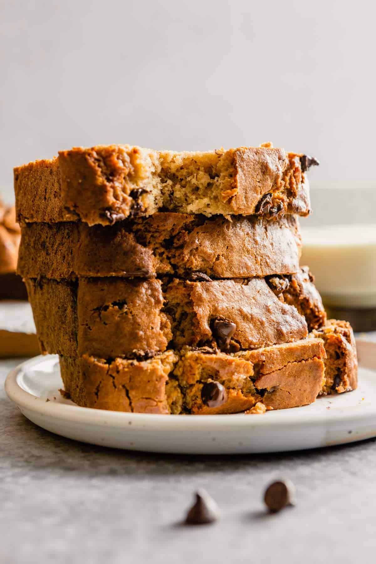 A stack of slices of peanut butter banana bread on a white plate.