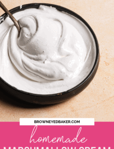 A black bowl with a silver spoon filled with homemade marshmallow cream and the words homemade marshmallow cream in a pink rectangle at the bottom of the picture.