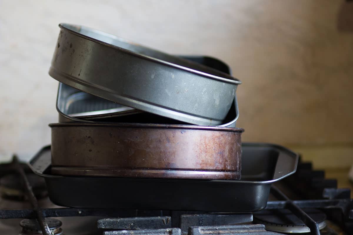 Baking pans stacked on a stove burner.