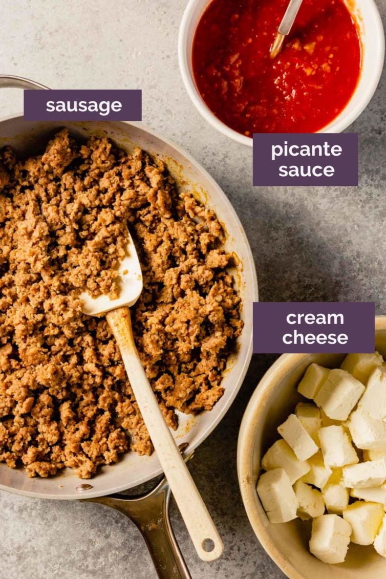 Three bowls on a grey counter with ingredients for sausage dip labeled with purple text boxes.