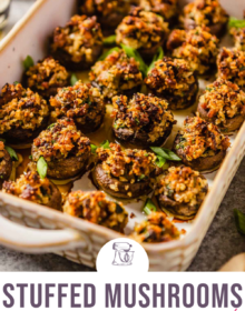 A rimmed baking dish filled with sausage stuffed mushrooms and the words Stuffed Mushrooms sausage and mascarpone at the bottom in pink.