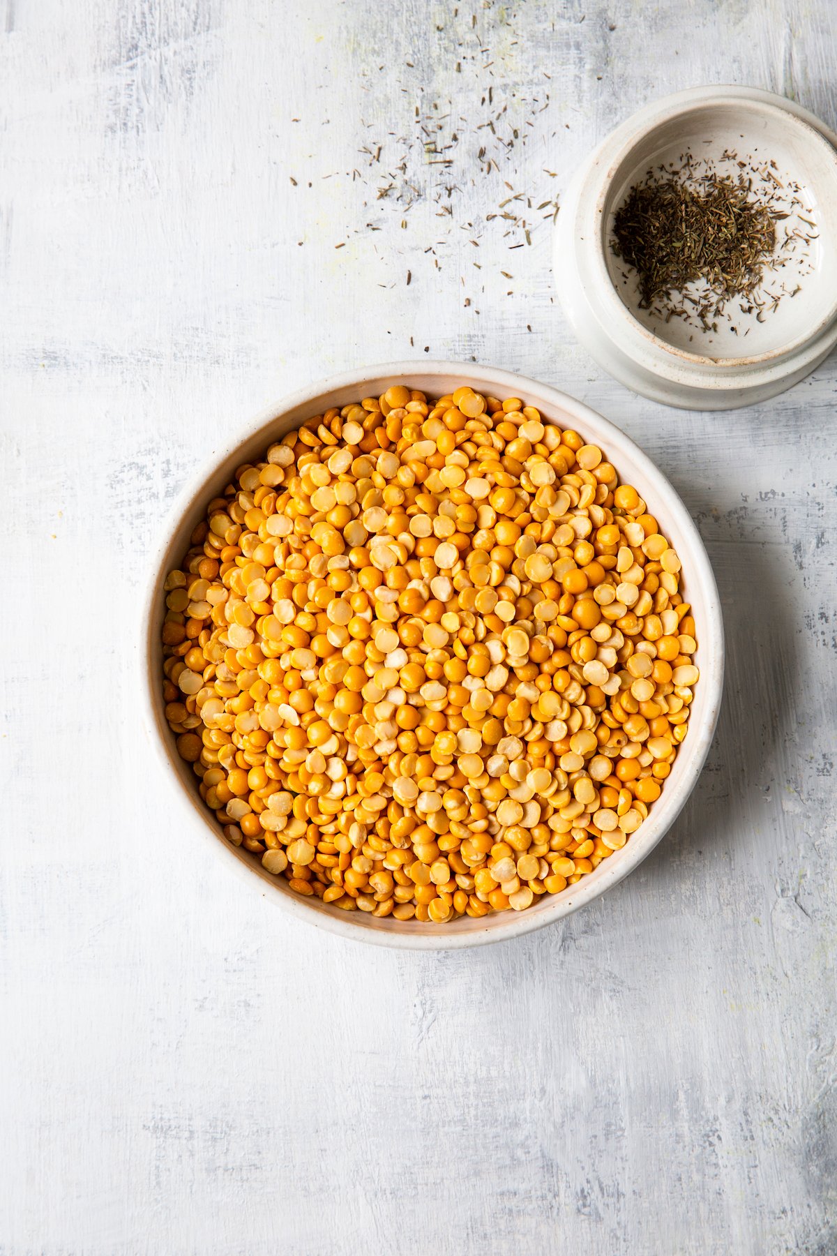 Overhead shot of yellow split peas and thyme in bowls
