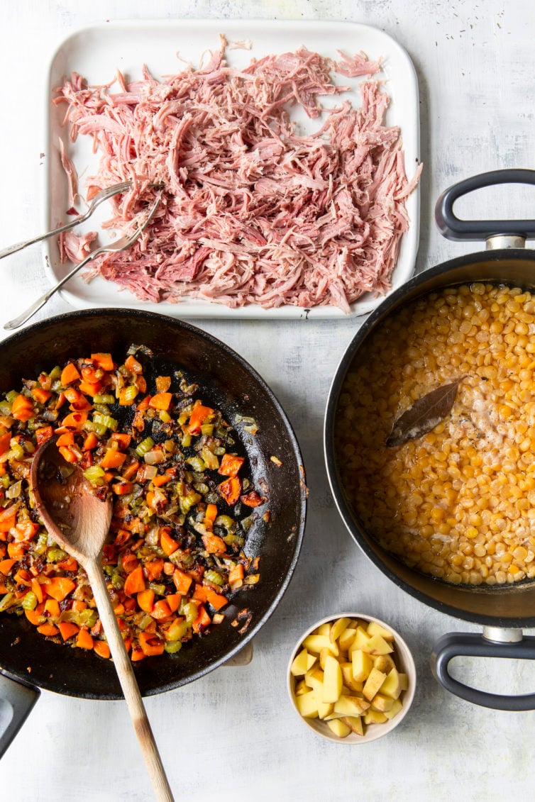 Overhead process shot of soup components: ham, mirepoix, split peas, and potatoes