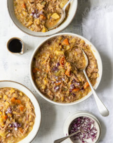 Three bowls of Ham and Split Pea Soup with bowls of chopped onions and balsamic vinegar