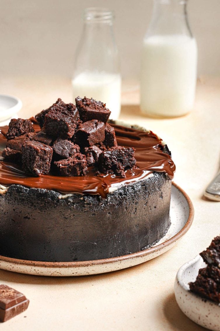 unsliced brownie cheesecake with oreo crust and chocolate ganache
