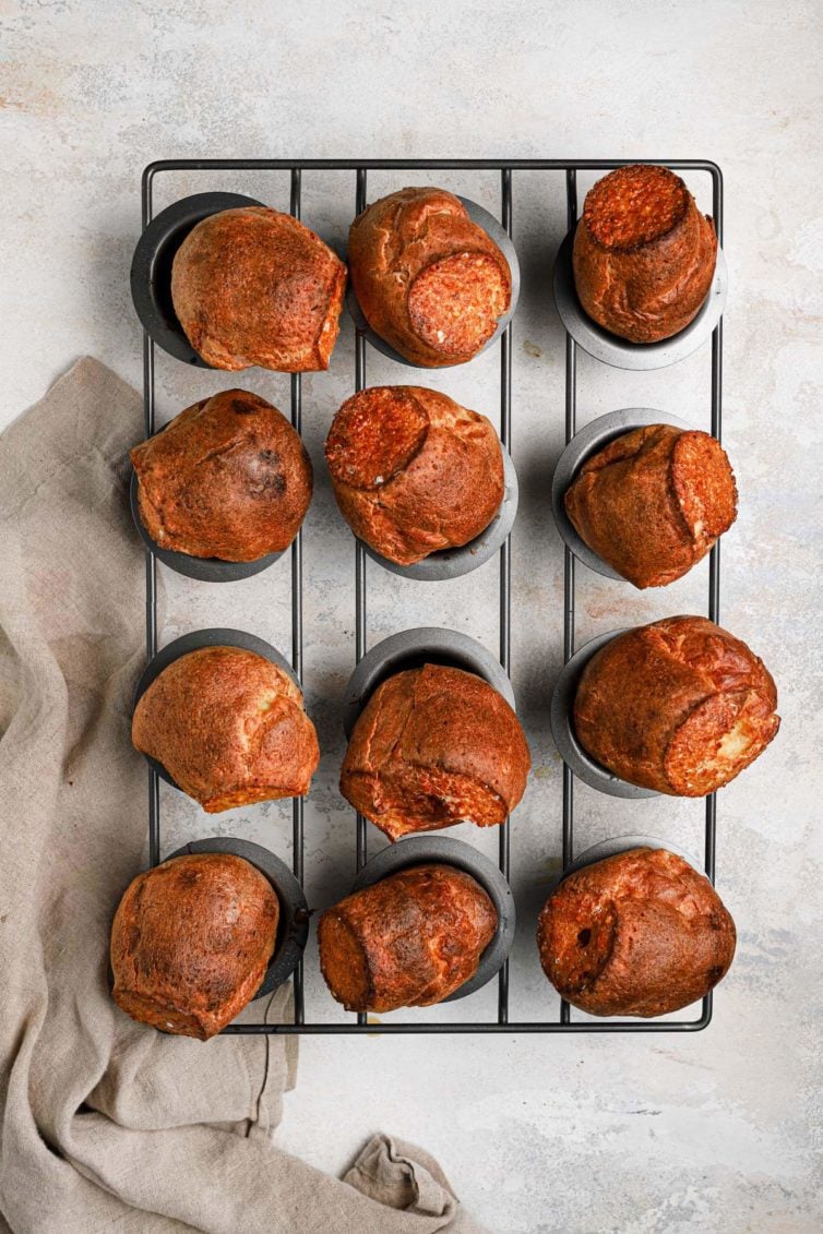 Golden brown baked breakfast popovers in a grey popover baking pan