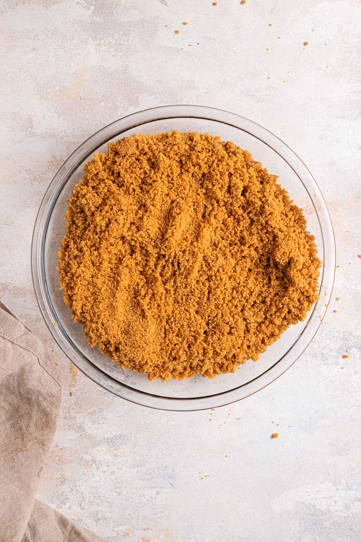 Graham cracker crust poured into a glass pie plate.