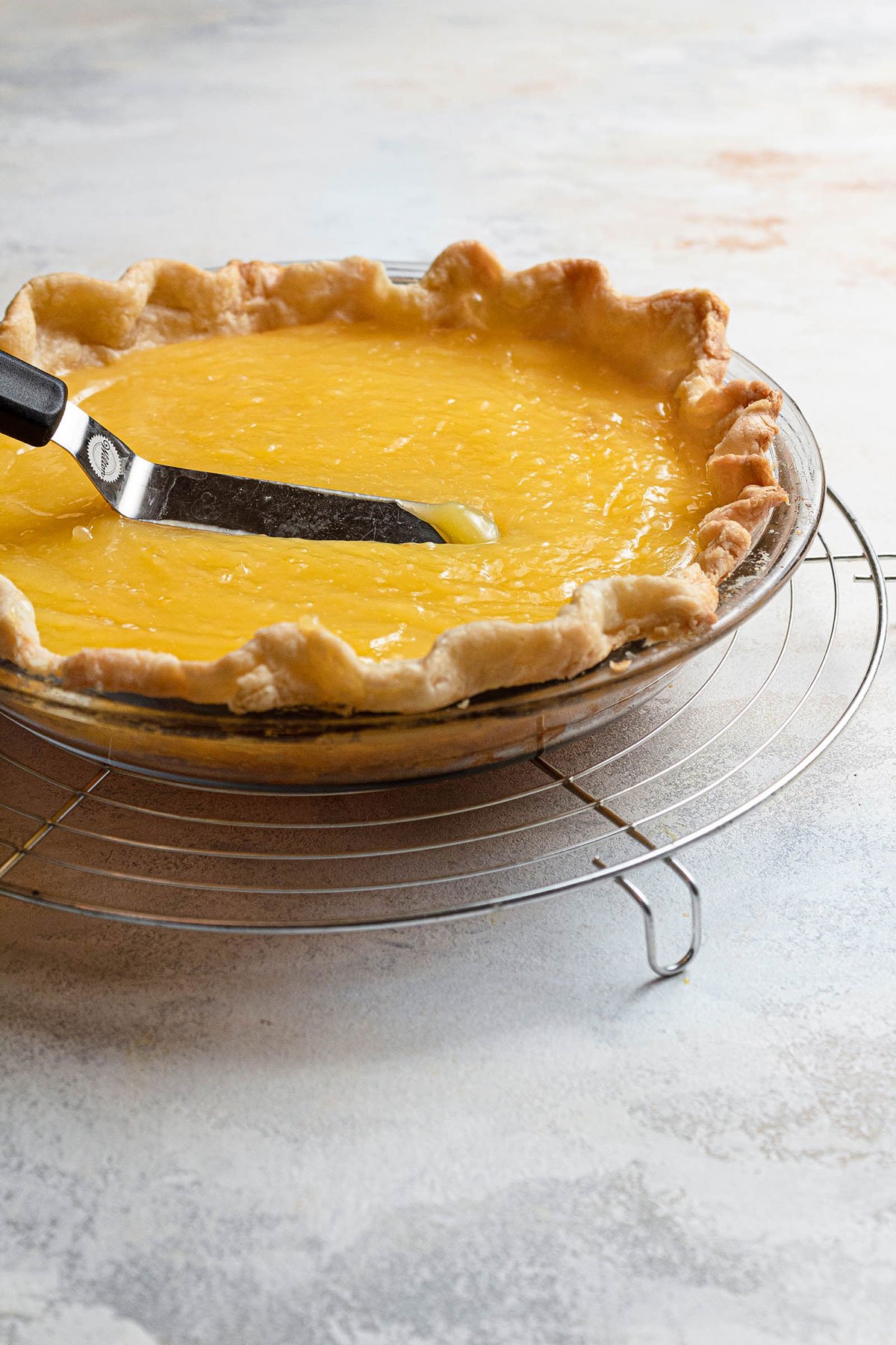 Smoothing the lemon filling into pie crust.