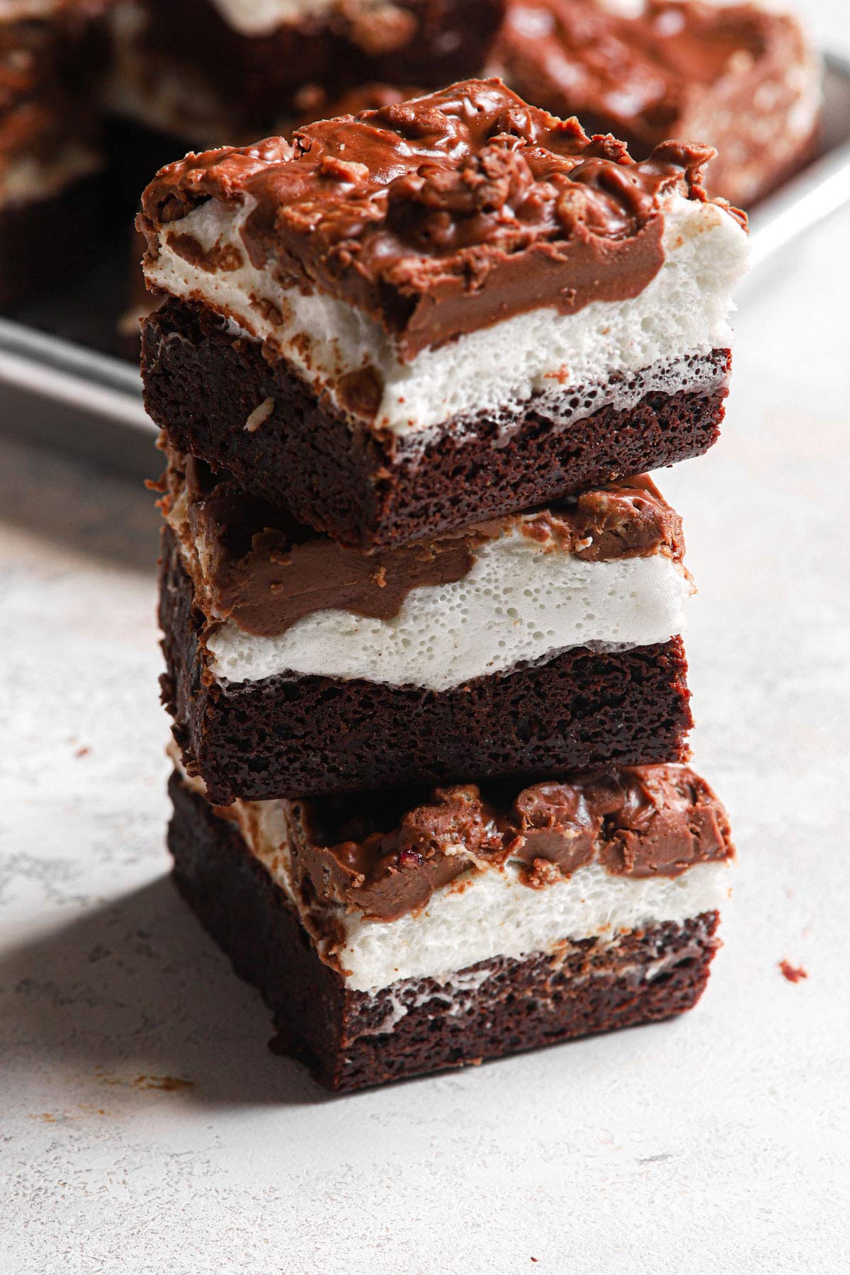 a stack of these fudgey marshmallow crunch brownie bars