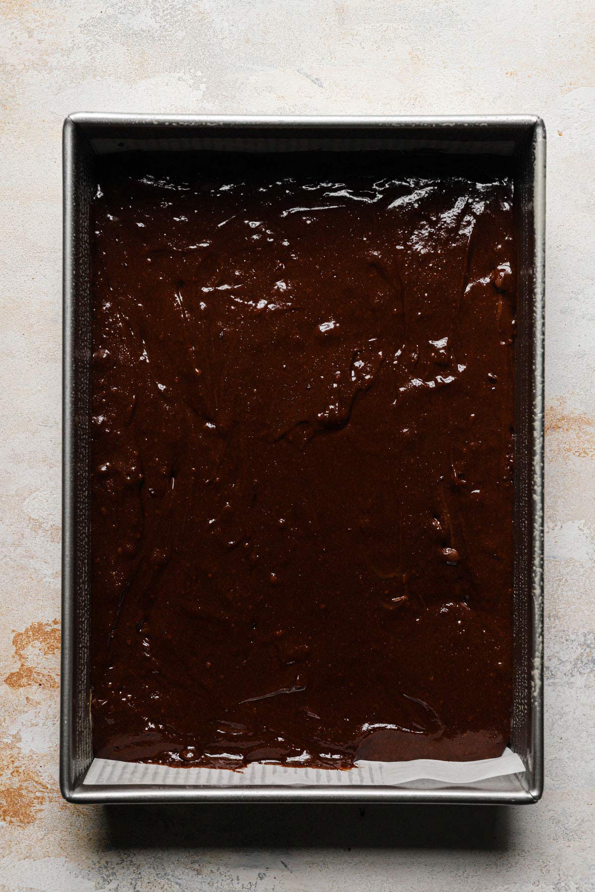 a baking tray of of these uncooked fudgey marshmallow crunch brownie bars