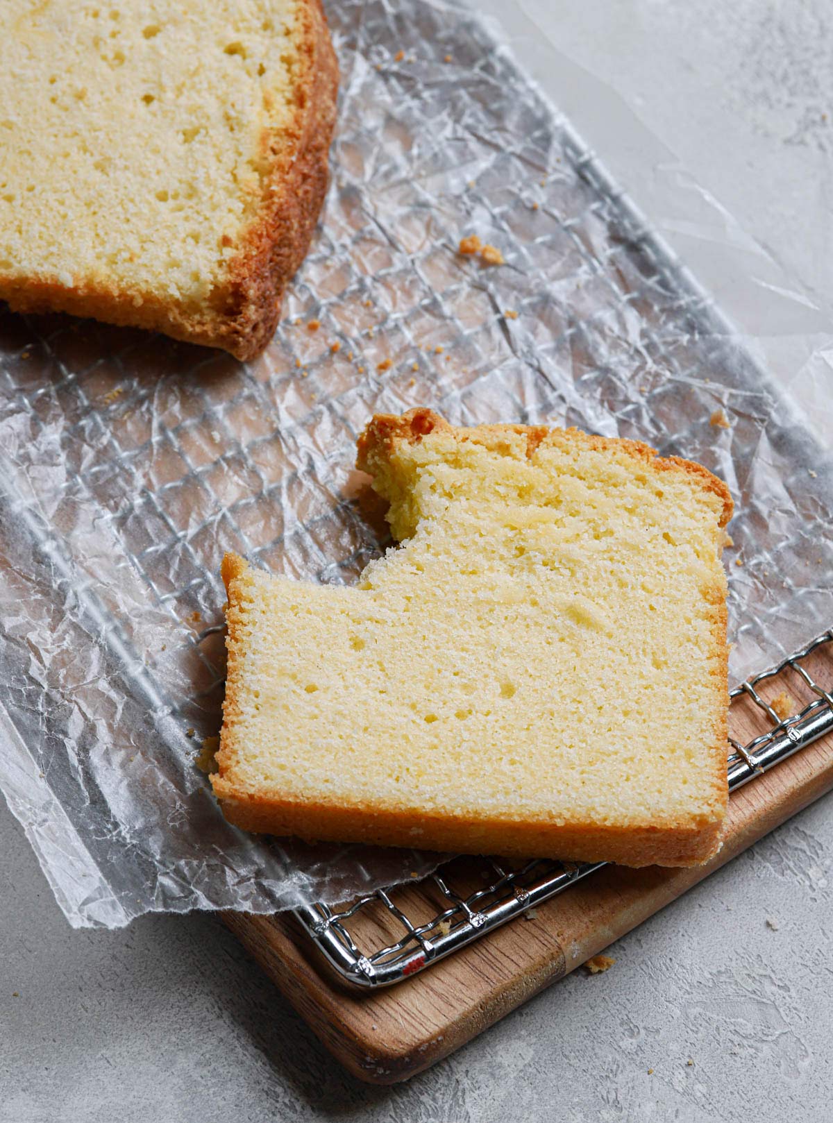 Slice of pound cake on a cooling rack with a large bite taken out of the corner.