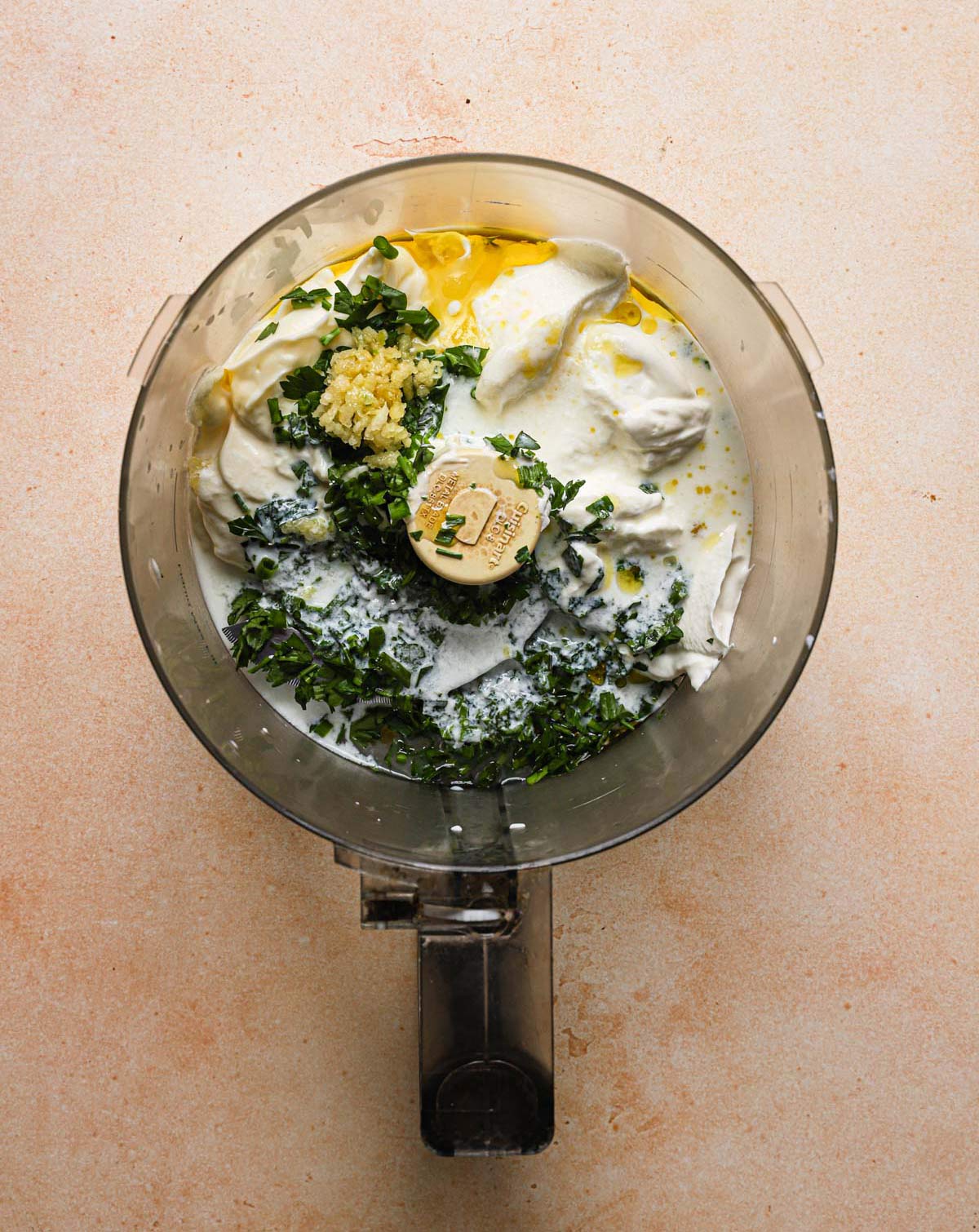 All ingredients for ranch dressing with buttermilk in the bowl of a food processor.