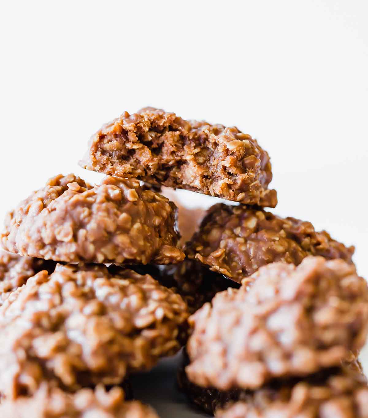 A no bake cookie with a bite taken out sitting atop a mound of no bake cookies.
