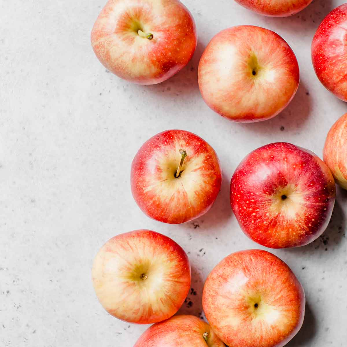 Red apples on a white countertop.