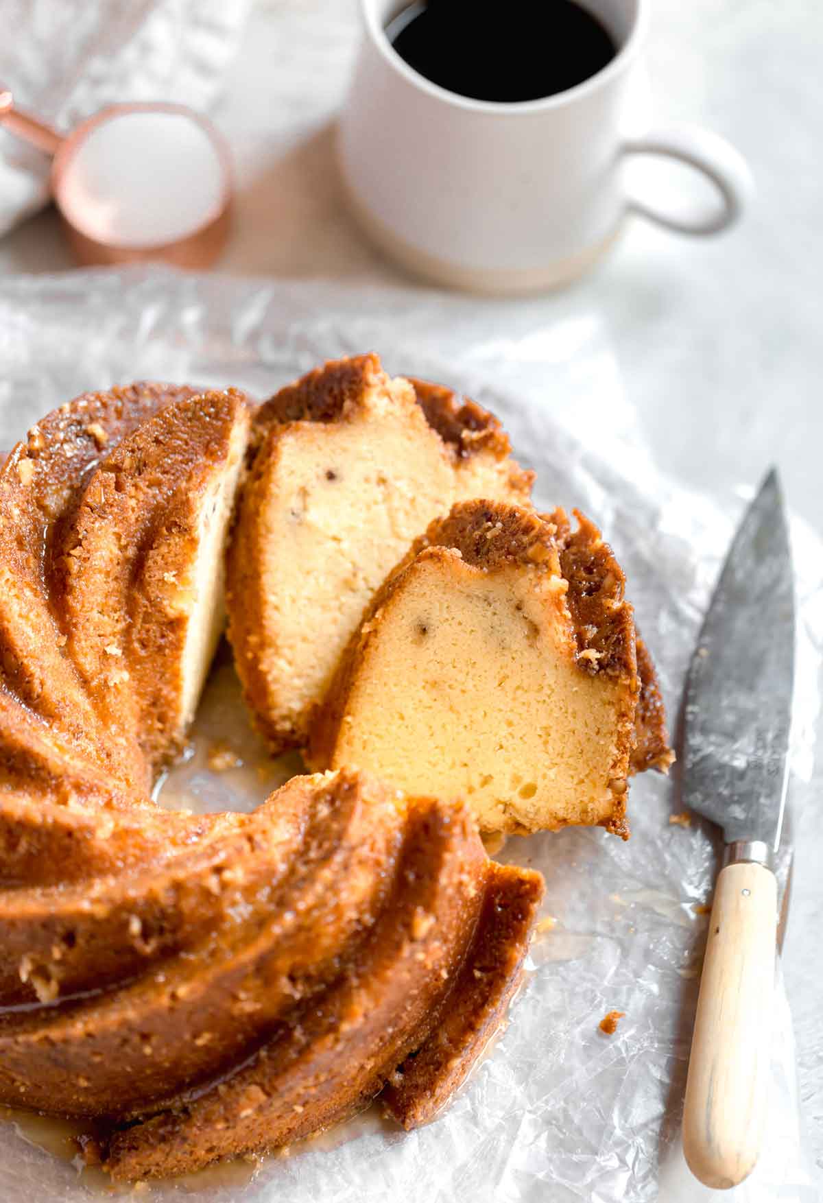 Rum cake on a serving platter with two slices cut and leaning against the cake.