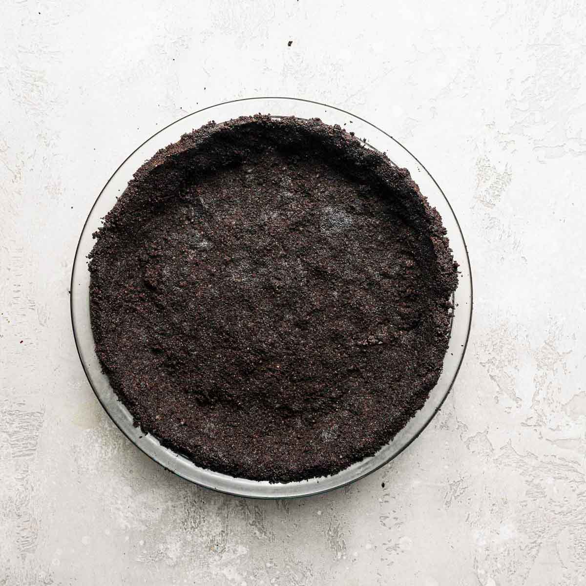 Oreo crumb crust pressed into a glass pie plate.