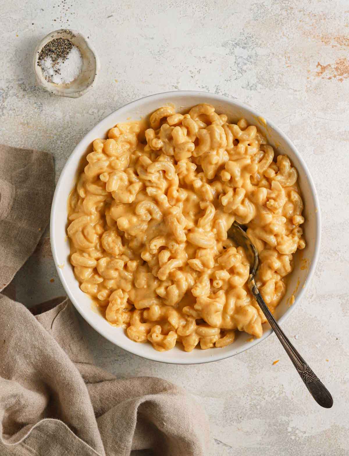 Overhead photo of a white bowl filled with creamy mac and cheese.