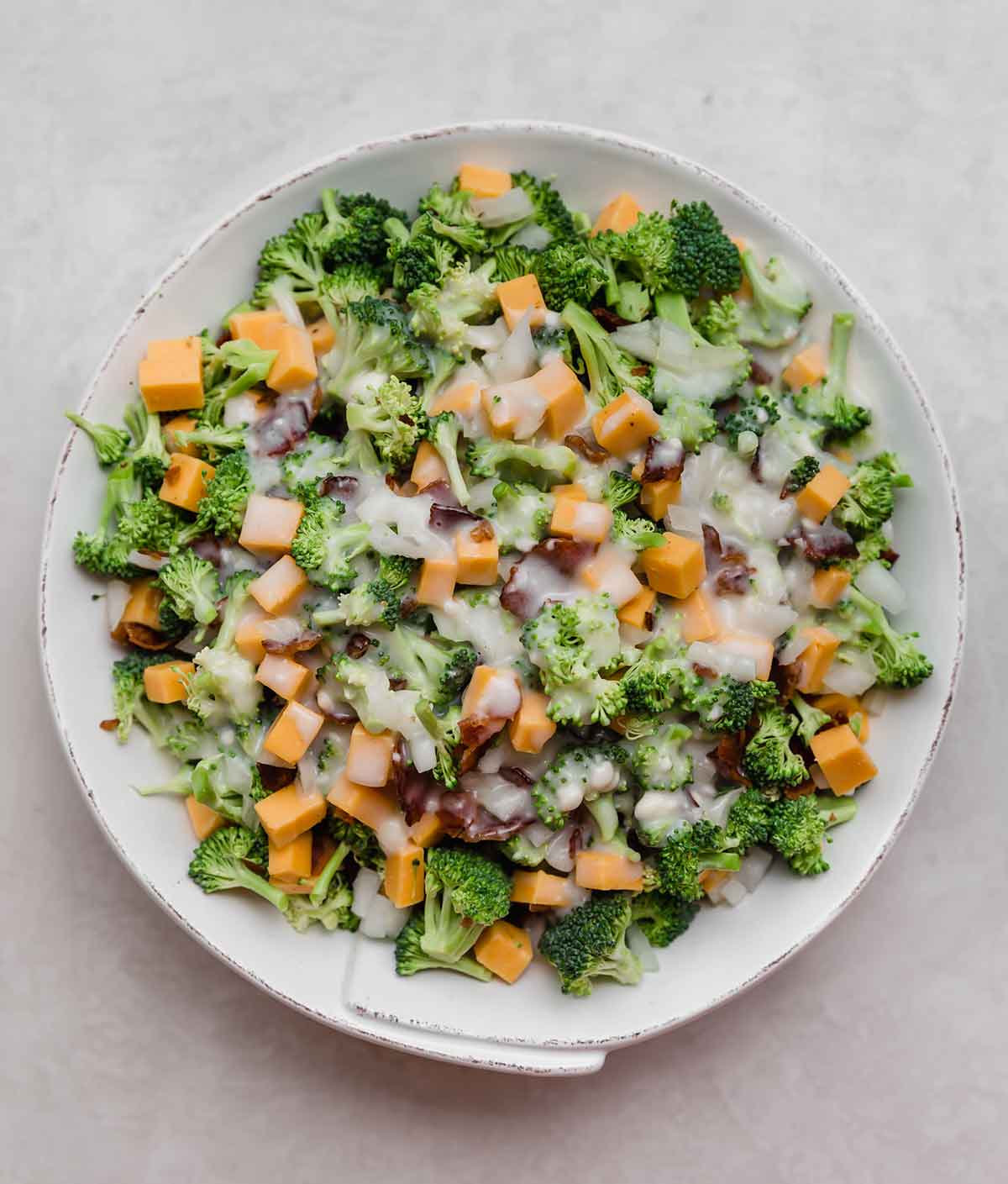 Overhead photo of broccoli salad in a rustic white bowl.