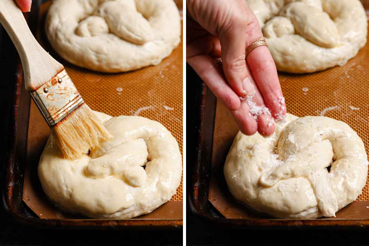 Soft pretzels being brushed with egg wash and sprinkled with salt before baking.