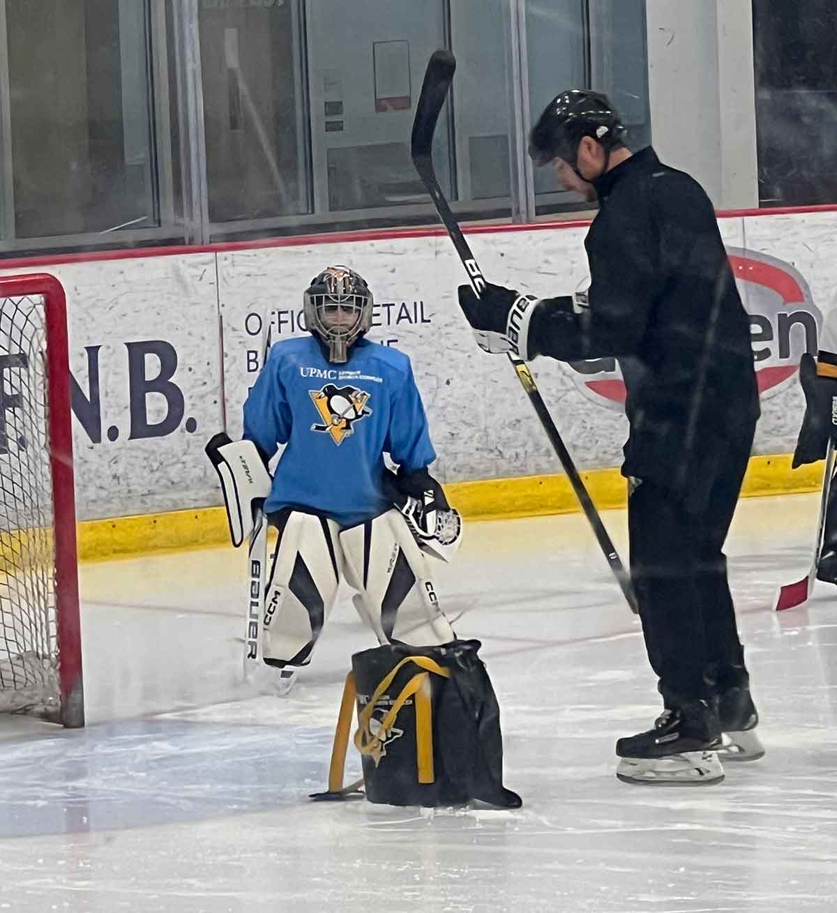 Little boy in goalie equipment during an on-ice training session.