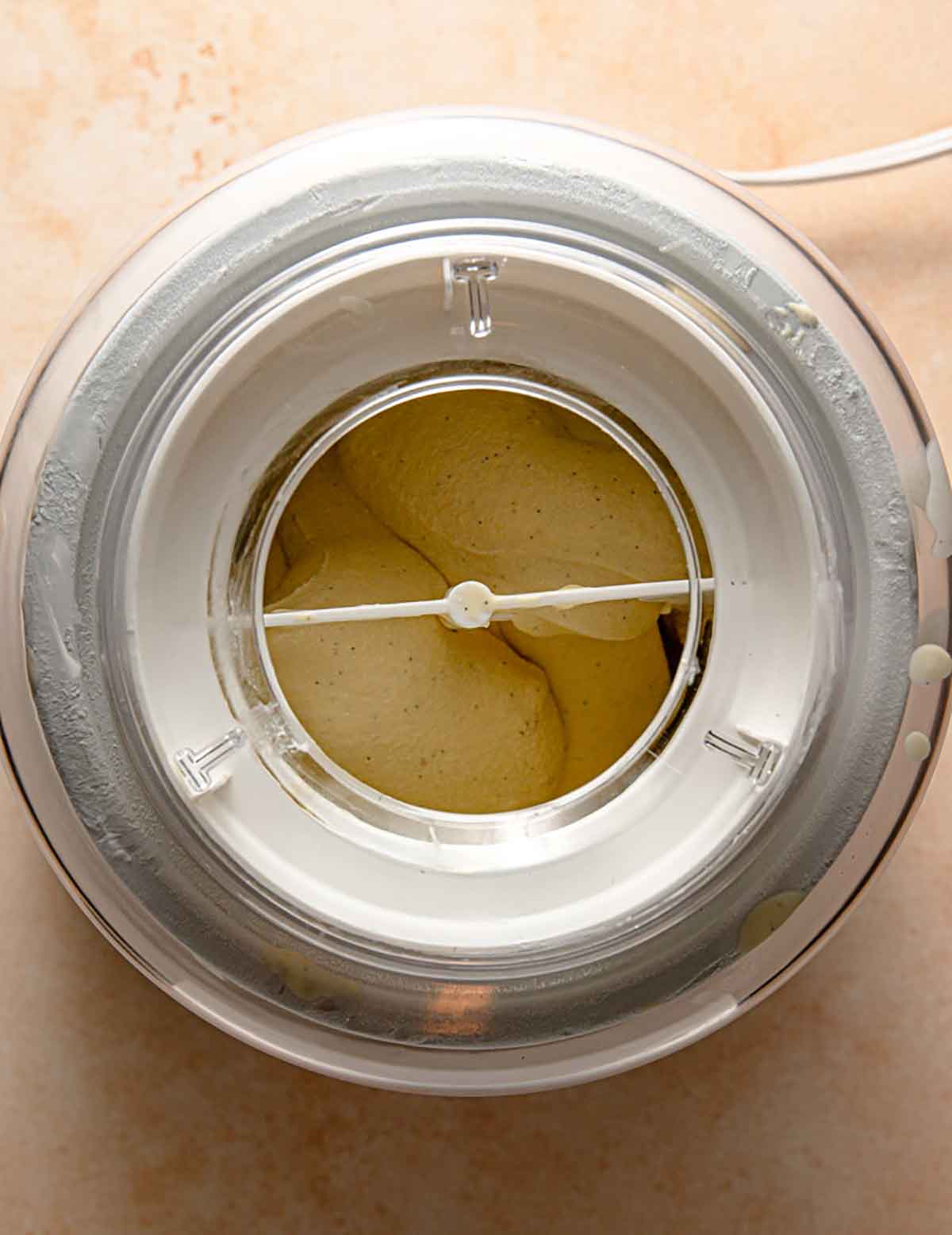 Overhead photo of vanilla ice cream churning in an ice cream maker.