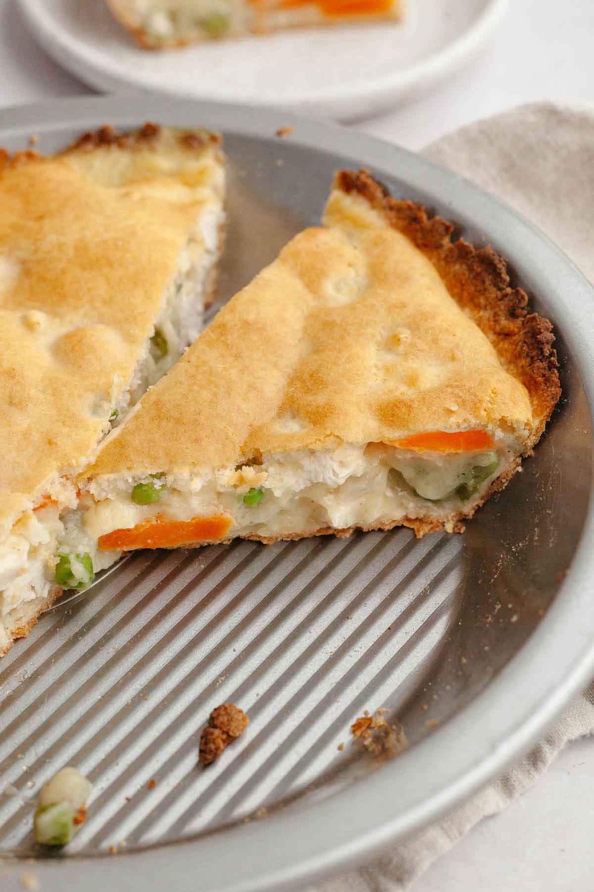 Slice of chicken pot pie cut away from the rest of the pie in the pie plate.