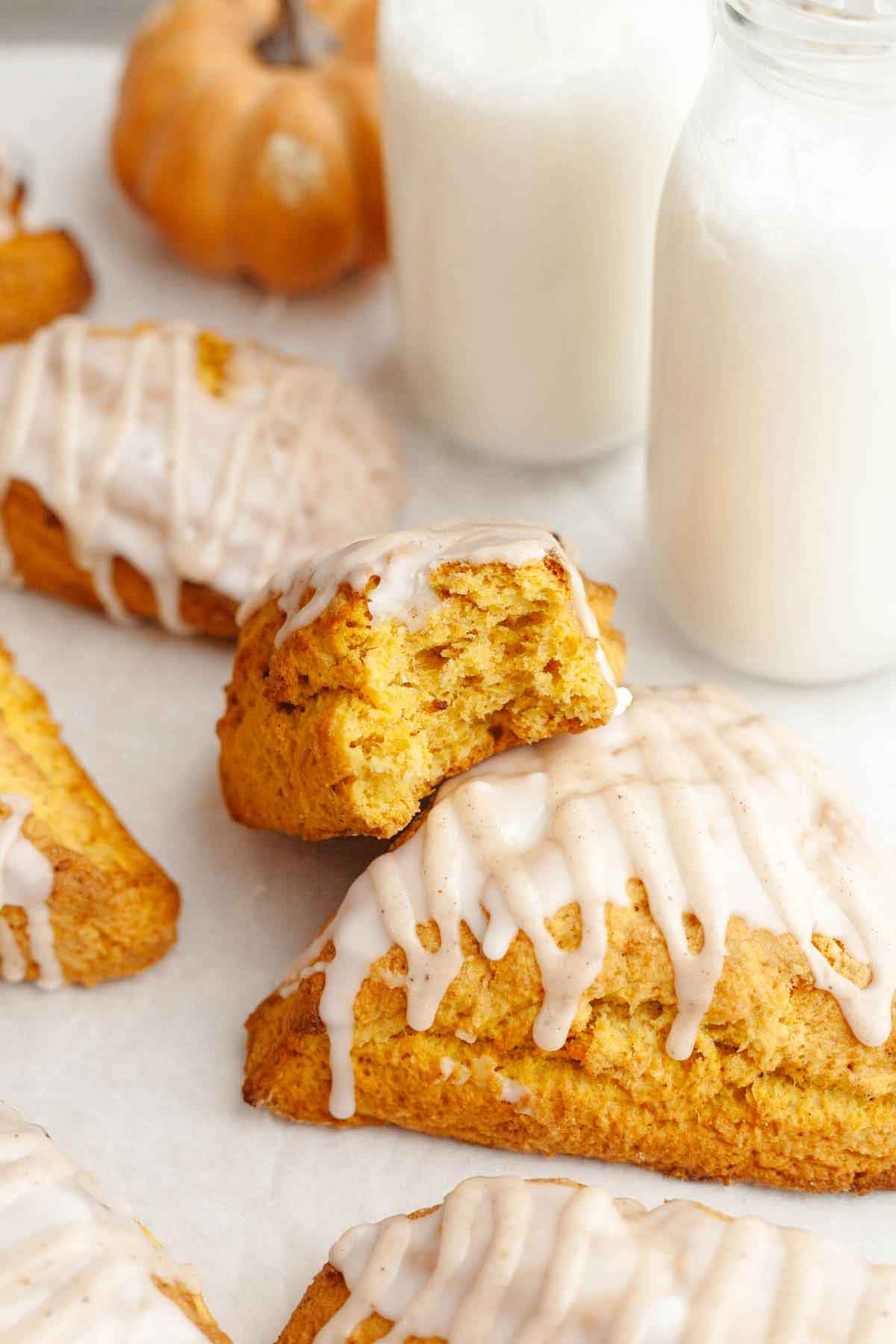 Half of a pumpkin scone resting on top of another whole pumpkin scone.