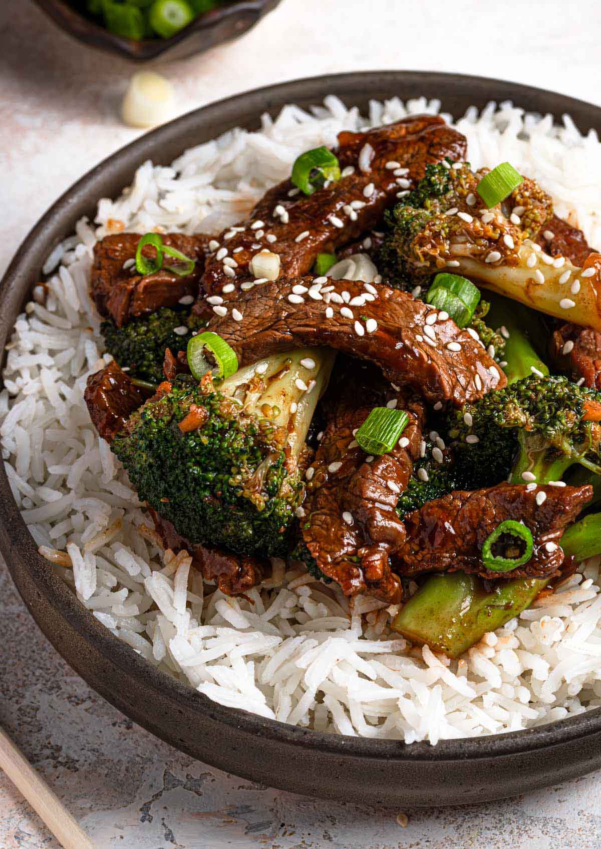 Close up photo of beef and broccoli stir fry over white rice.