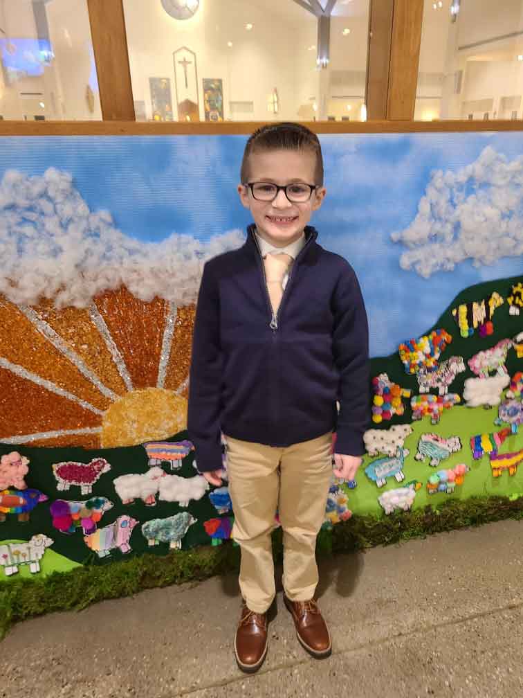 Little boy standing in front of a display in a church.