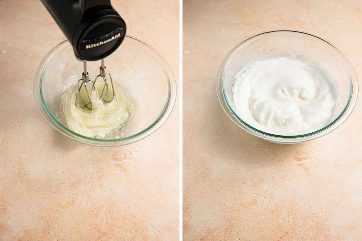 Egg whites being whipped to stiff peaks with a hand mixer in a glass bowl.