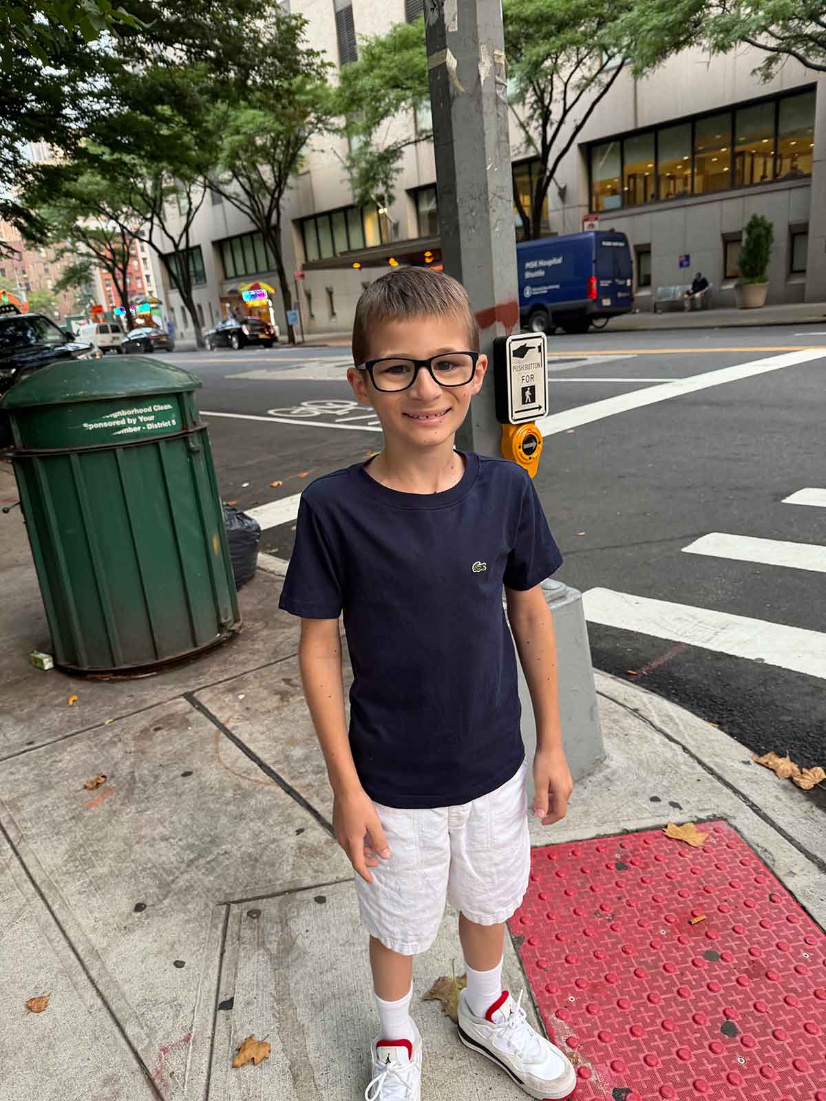 Little boy standing on a street corner in New York City.